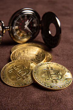 Bitcoin, bitcoin coins and a vintage pocket watch placed on a brown leather background, selective focus.