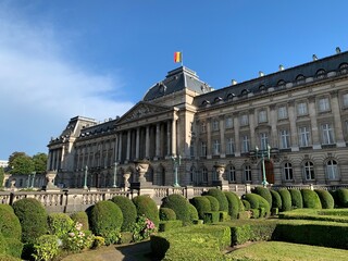 Front facade of The Royal Palace of Brussels. It is  is the official palace of the Belgian Royal family in the city centre. Belgian flag is waiving on top of the building. Bruxelles, Belgium