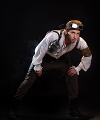A guy in a steampunk image, a pilot or a mechanic. Retro style, fantastic image. portrait on black.