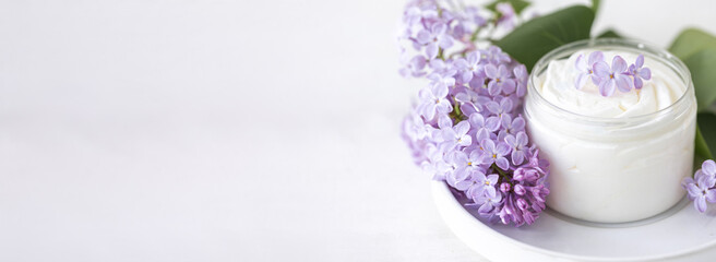 Fototapeta na wymiar Concept of pure natural organic plant-based ingredients in cosmetology, herbal and flower extract. Lilac for anti-age and anti-acne therapy, gentle face and body skin care. Banner copy space