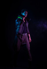 A guy in a cyberpunk image, aiming a gun at someone. a futuristic character. A young man in neon lighting on a black background