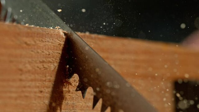 Super slow motion of cutting wood with a hand saw. Low depth of focus. Filmed on high speed cinema camera, 1000 fps.