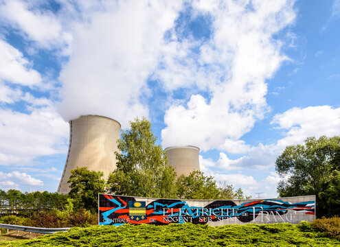 Nogent-sur-Seine, France - September 1, 2020: Welcome sign of the nuclear power plant of Nogent-sur-Seine, run by public electricity utility company EDF, and the two cooling towers releasing vapor.