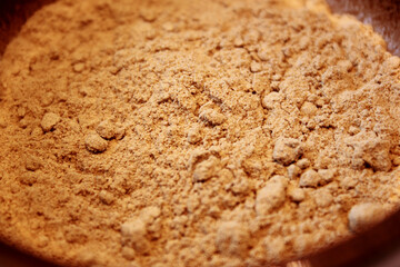 close-up of ginger spice powder in a brown bowl