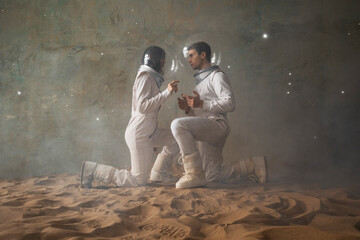 Obraz premium Astronauts on a desert planet, a man and a woman in white spacesuits with large glass helmets sit with their heads bent towards each other, a hologram of the starry sky on top. Melancholy in space