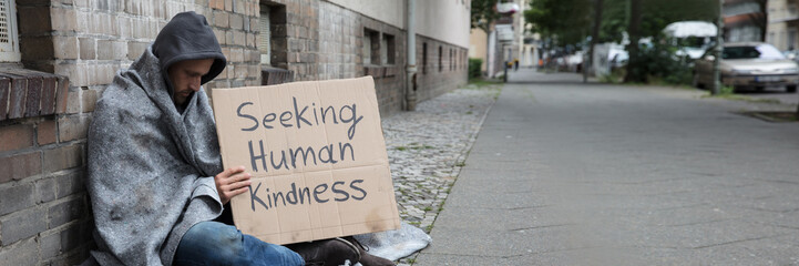 Beggar Showing Seeking Human Kindness Sign On Cardboard - obrazy, fototapety, plakaty