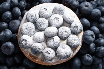 sweet dessert cake with pudding cream and blueberries sprinkled with sugar