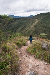 Young woman walking on Bogota mountain path through a rocky path