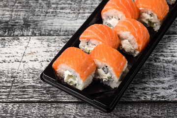 Sushi, rolls, sushi with fish on a white wooden background, side view