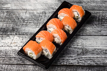 Sushi, rolls, sushi with fish on a white wooden background, side view