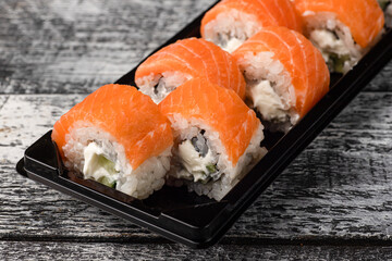 Sushi, rolls, sushi with fish on a white wooden background, side view