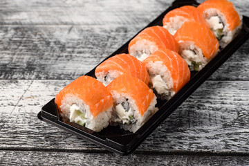 Sushi, rolls, sushi with fish on a white wooden background, side view