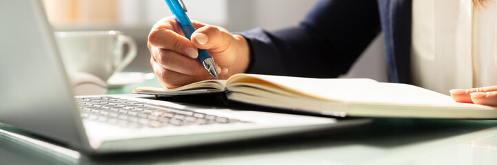 Close-up Of A Businesswoman's Hand Writing Note In Diary