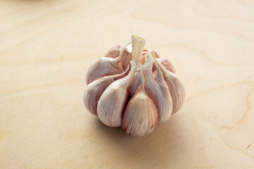 Raw garlic with segments on a wooden table background, close-up. Organic garlic for publication, poster, screensaver, wallpaper, postcard, banner, cover, post. Food cook rustic still