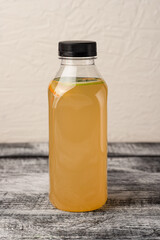 Lemonade, homemade lemonade in a bottle, on a white wooden background