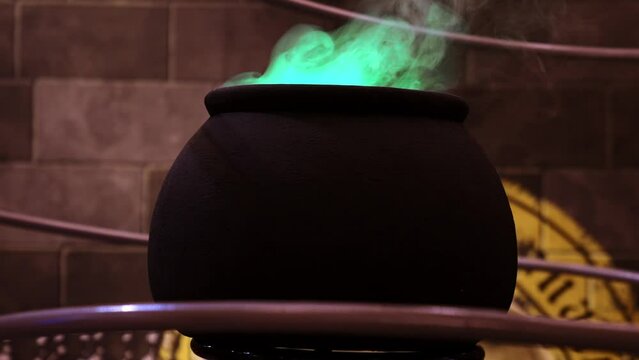 Vintage witcher cauldron with magic potions and books for Halloween. Magic miracle pot in Harry Potter style.