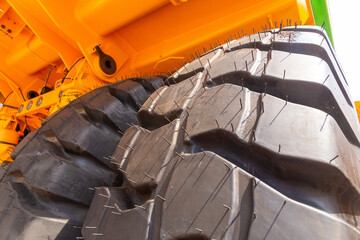 Huge rear wheels of dump truck at unusual angle closeup.