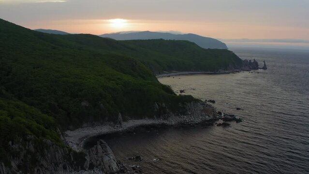 Sea stack vertically sticking out of the water at dawn. Drone view, panoramic view. Cape Laplace, East Sea