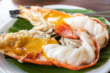 Close up view at one Grilled Giant River Prawn and fat shrimp serve on white plate on wooden table.