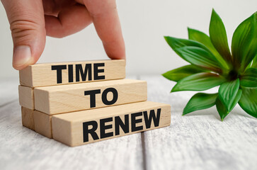 The word TIME FOR RENEW is written on a wooden blocks on white desk