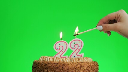 Cake with lighted candle number 22. Green screen background. Isolated.