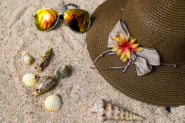 beach accessories on the yellow background - sunglasses, towel. flip-flops and striped hat. summer...