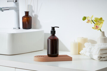 Cosmetics product and cotton towels, cottons pad with green plant on white table inside a bathroom background ceramic.