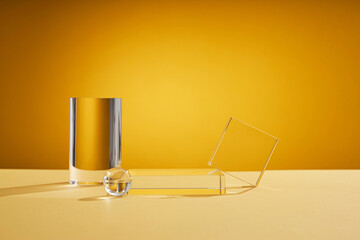Front view of transparent podium glassware decorated in yellow background with blank space 