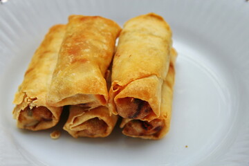 Fried spring rolls placed in a white plate, fried spring rolls are a popular Asian dish.