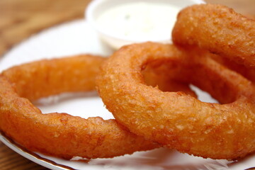 Fried onions served in small white plates in American restaurants.