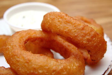 Fried onions served in small white plates in American restaurants.