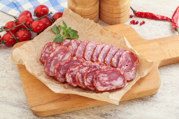 Sliced salami sausages over board