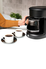 Woman's hands serve coffee prepared in a coffee maker to start the day with the benefits of antioxidants, protects against cancer, fights Alzheimer's and Parkinson's
