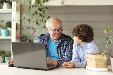 Grandfather and grandson study on the computer at home ,back to school