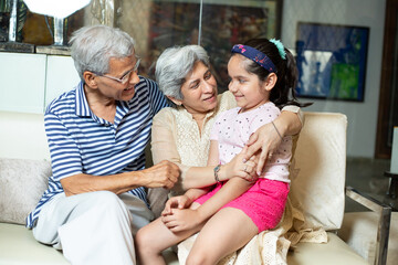 Happy indian grandparents spend time with grandchild, Asian senior retired people sitting together...