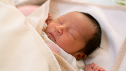 すやすや眠る生まれた日の新生児