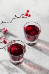Two glasses of cherry liqueur on white background. Christmas or new year party celebration concept. Winter holidays concept.