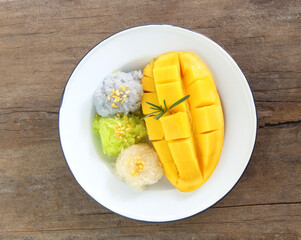 Thai famous dessert - Top view of sweet fresh ripe mango with three color of sticky rice , green...