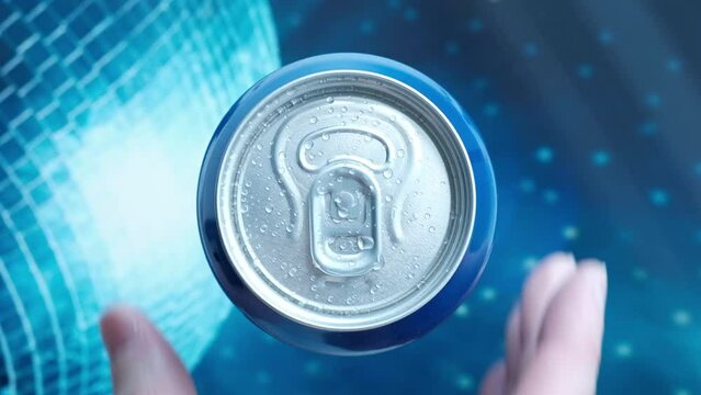 hand takes a metal can of a cool drink