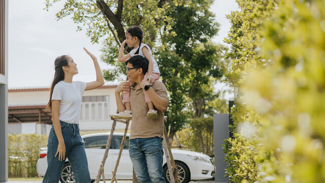 Family having fun time at home. Asian family with little kids daughter playing together in house backyard outside. Happy family time.