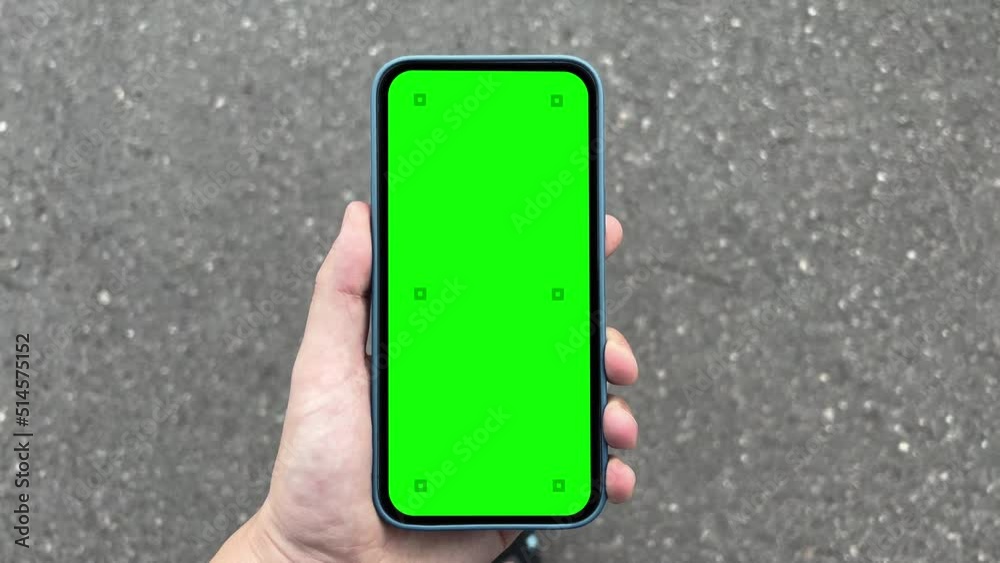 Wall mural man takes the phone with a blank green screen and tracking markers while walking - call or applicati