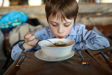 Kid eating dumplings with broth