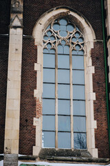 Elongated vintage vertical window on the facade of the ancient building. Baroque and Gothic...
