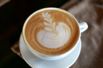 Cup of patterned coffee on table