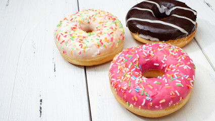 donuts of different colors on a white table