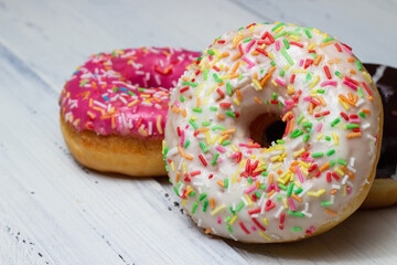 donuts of different colors on a white table