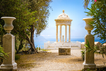 Front view through two stone pillars with vases of the terrace of Son Marroig with a pavilion...