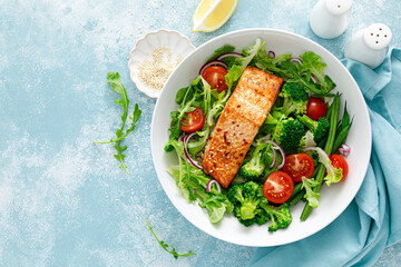 Grilled salmon fish fillet and fresh tomato vegetable salad with lettuce, arugula, broccoli and green beans. Healthy food, mediterranean diet - obrazy, fototapety, plakaty
