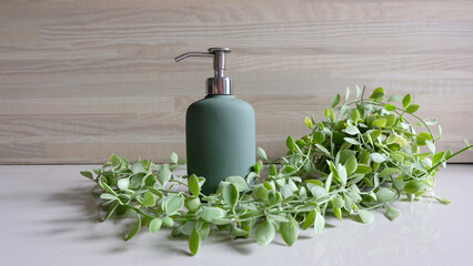 Organic cosmetic product in a green dispenser on a background of green leaves. Eco friendly product.