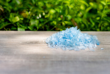 A Pile of PET bottle flakes with green tree blur background